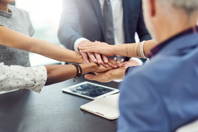 Cropped shot of businesspeople joining their hands together in unity